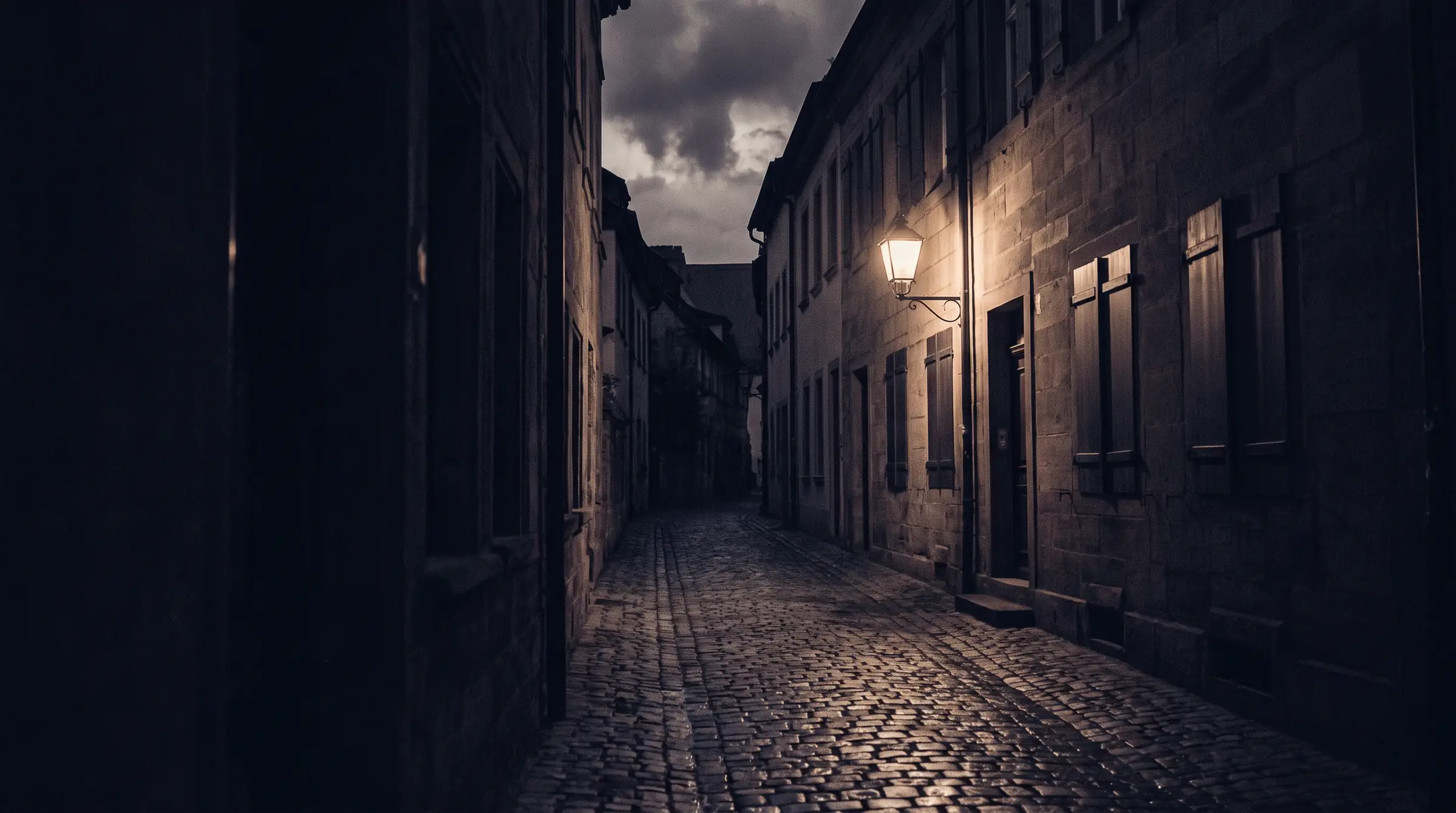Enge Kopfsteinpflastergasse einer Altstadt bei Nacht