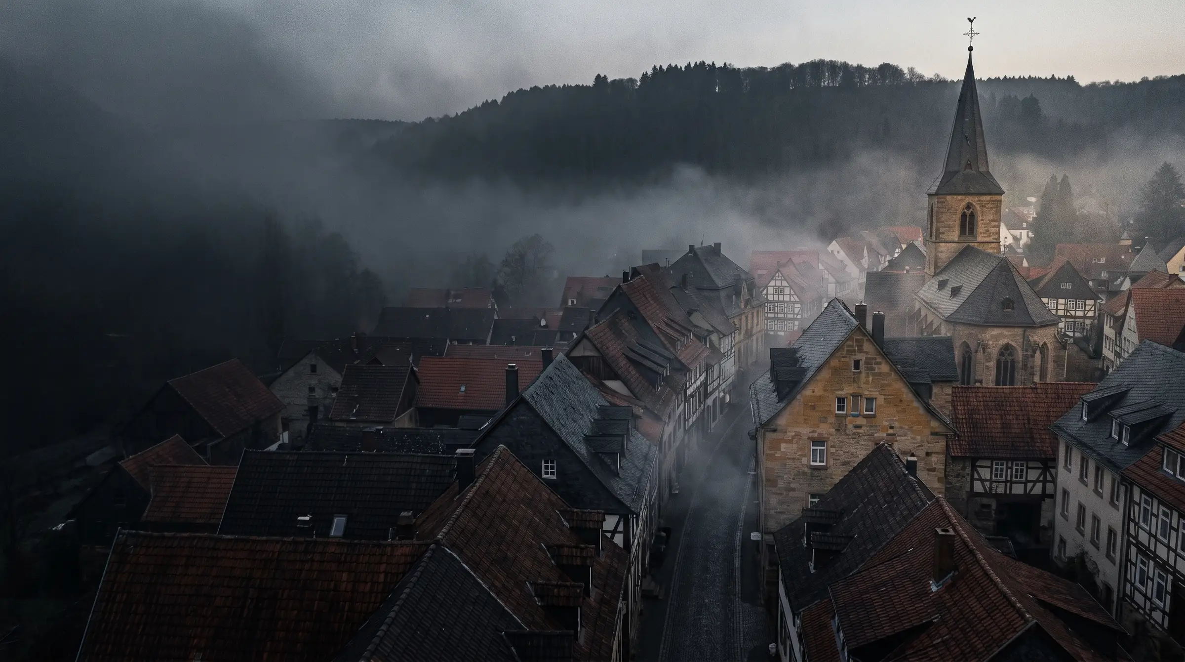 Ziegeldächer einer Altstadt im Morgennebel